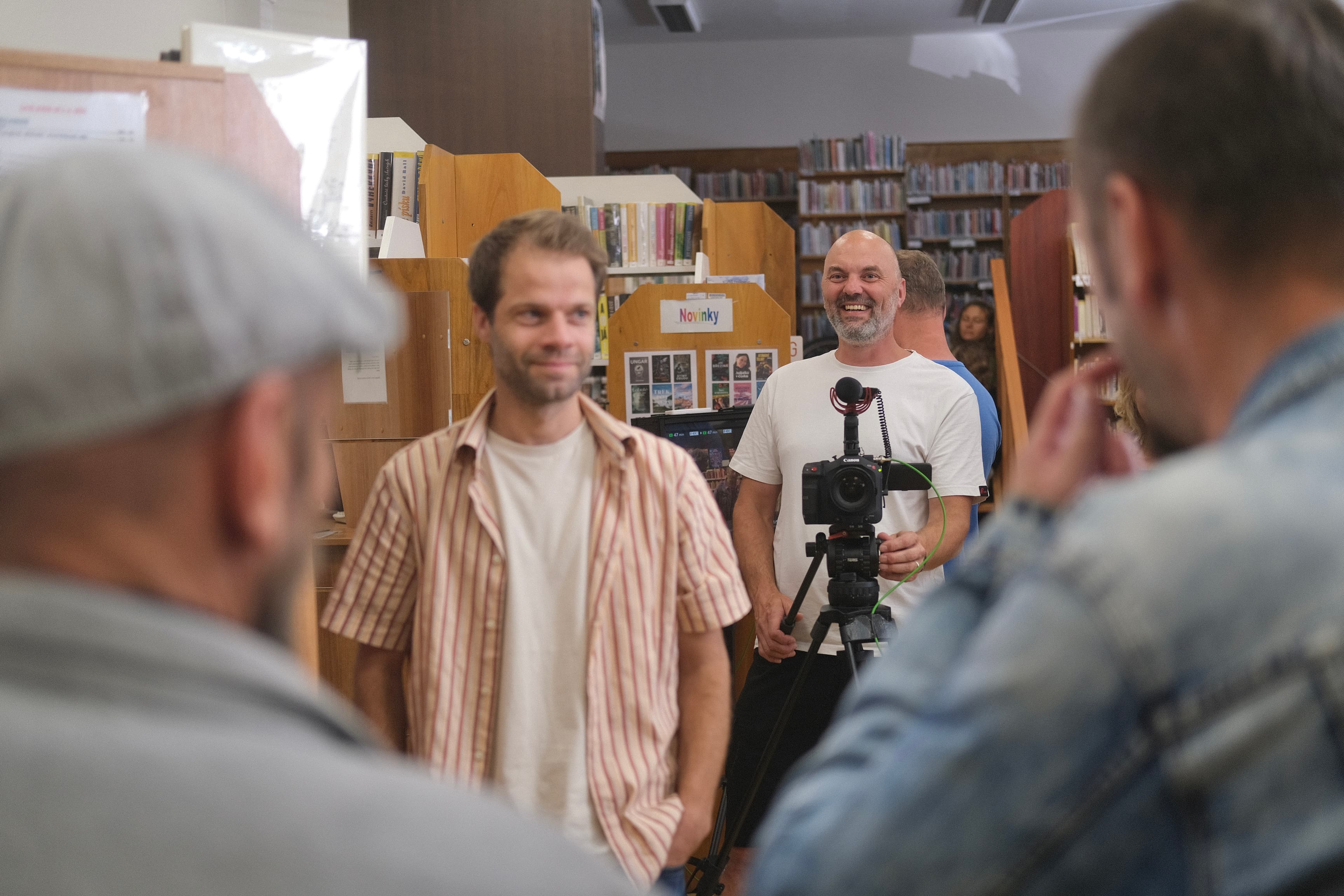 Režisér Michal Griga aranžuje další záběr svého filmu při natáčení v boskovické knihovně
